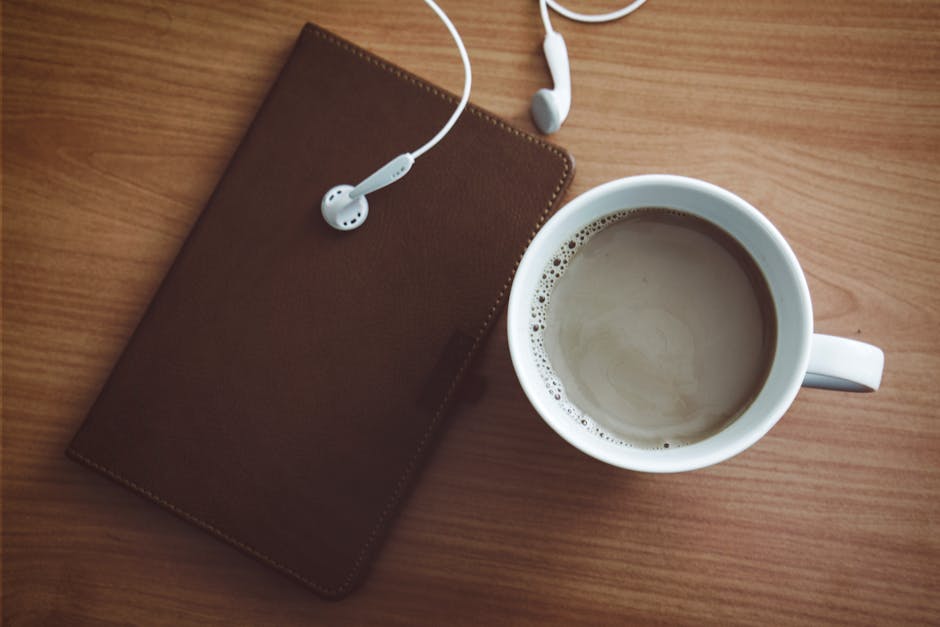 person listening to music with headphones morning routine journal coffee