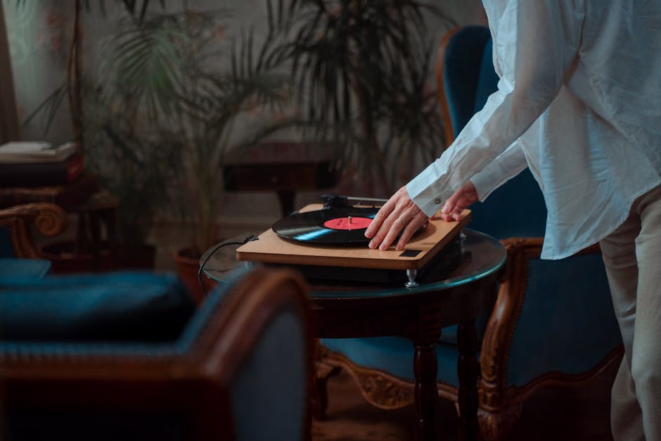 person listening to vinyl record in cozy living room evening