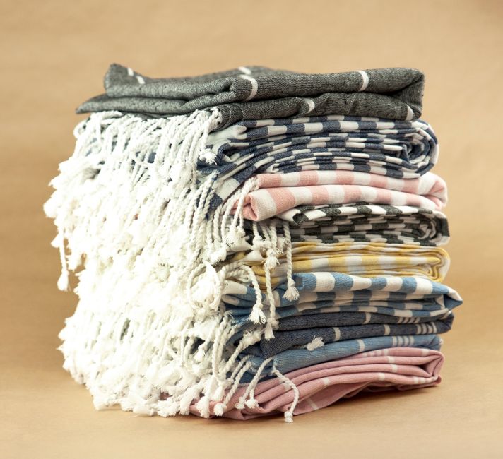 folded beach towels on sandy beach with ocean background lifestyle