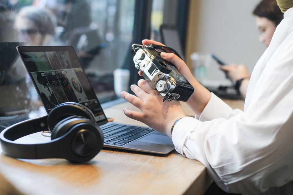 pexels-17580654 person wearing headphones in coffee shop working on laptop lifestyle music