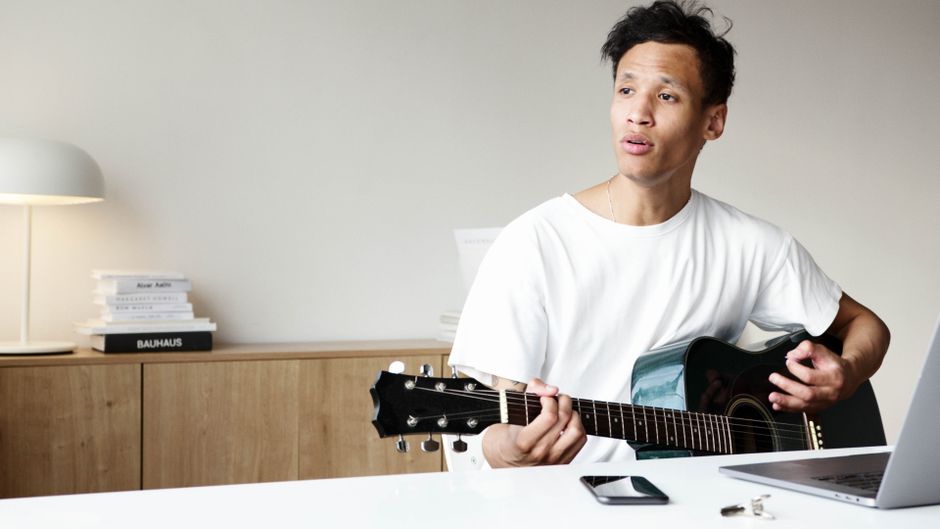 pexels-4680085 person practicing guitar with timer at home minimalist lifestyle
