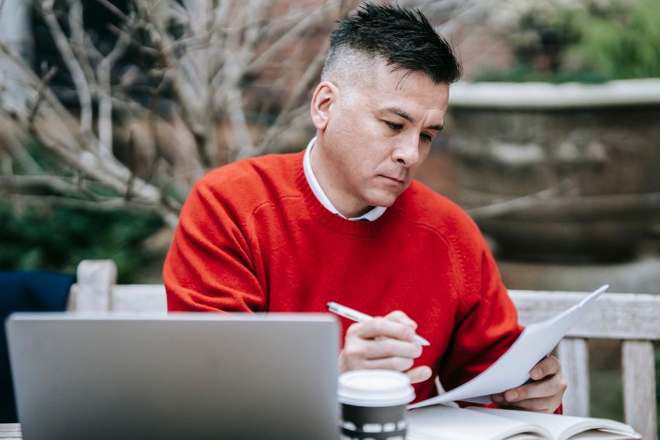solopreneur working on laptop reviewing cash flow dashboard notebook coffee