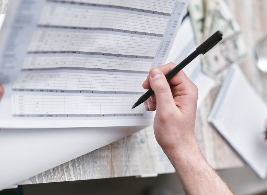 business owner reviewing cash flow forecast spreadsheet in office