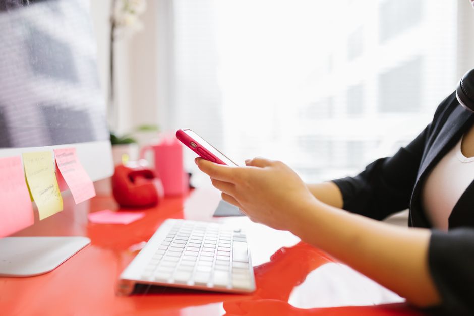 person organizing digital workspace laptop smartphone notifications focus mode
