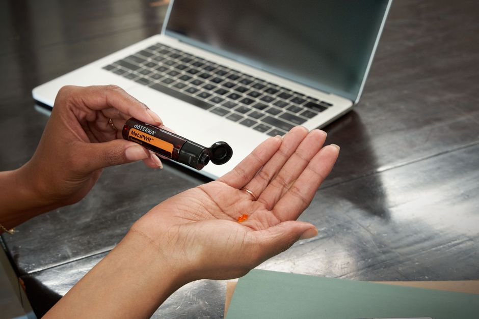 person holding small wellness kit mints lotion stress ball water bottle desk