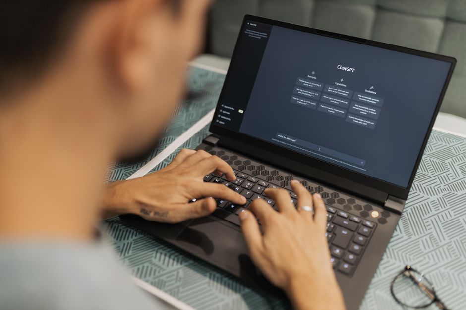 office team working on laptops with AI chatbot on screen cybersecurity governance