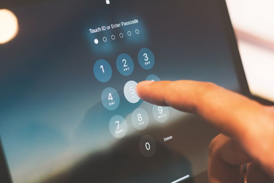 pexels-27742642 person unlocking smartphone with face id passkey login on laptop
