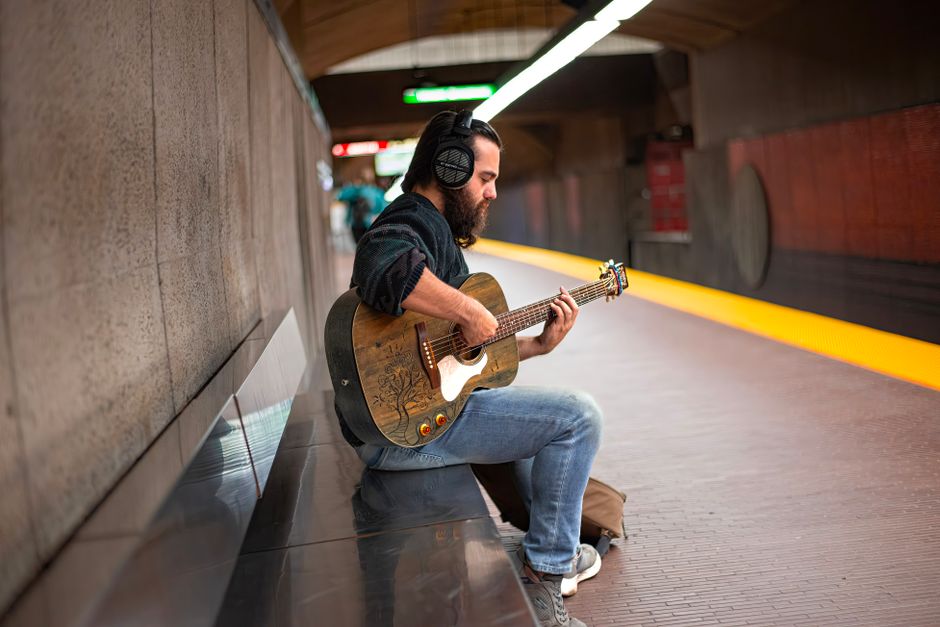 musician commuting with headphones city train focused morning