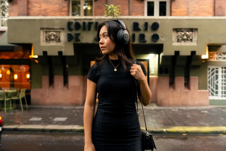 person listening to music on headphones walking in city evening lifestyle