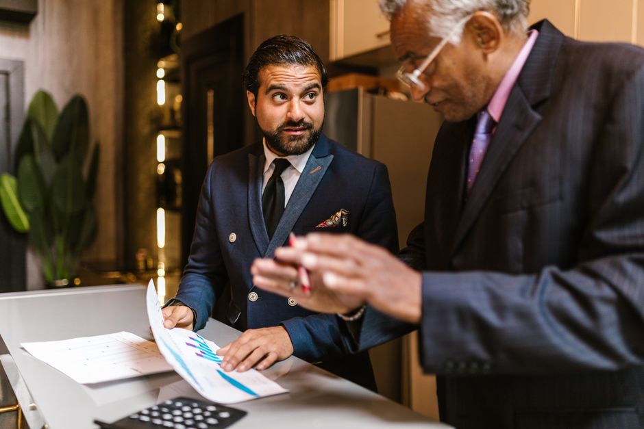 consultant meeting with small business owner reviewing monthly report cash flow