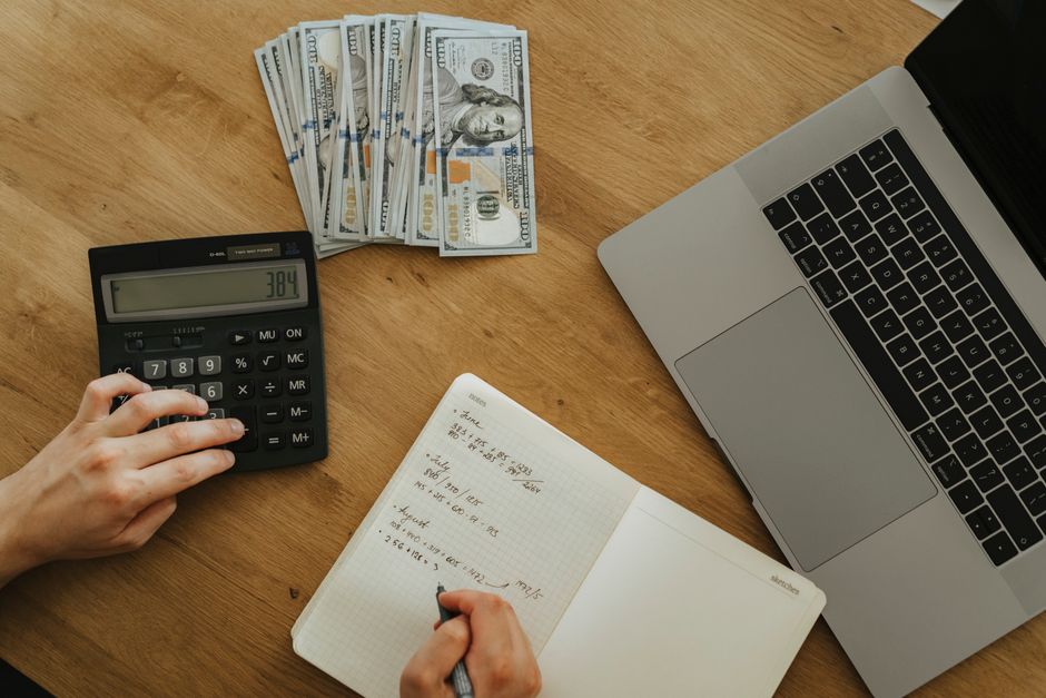 small business owner reviewing cash flow dashboard on laptop notebook calculator