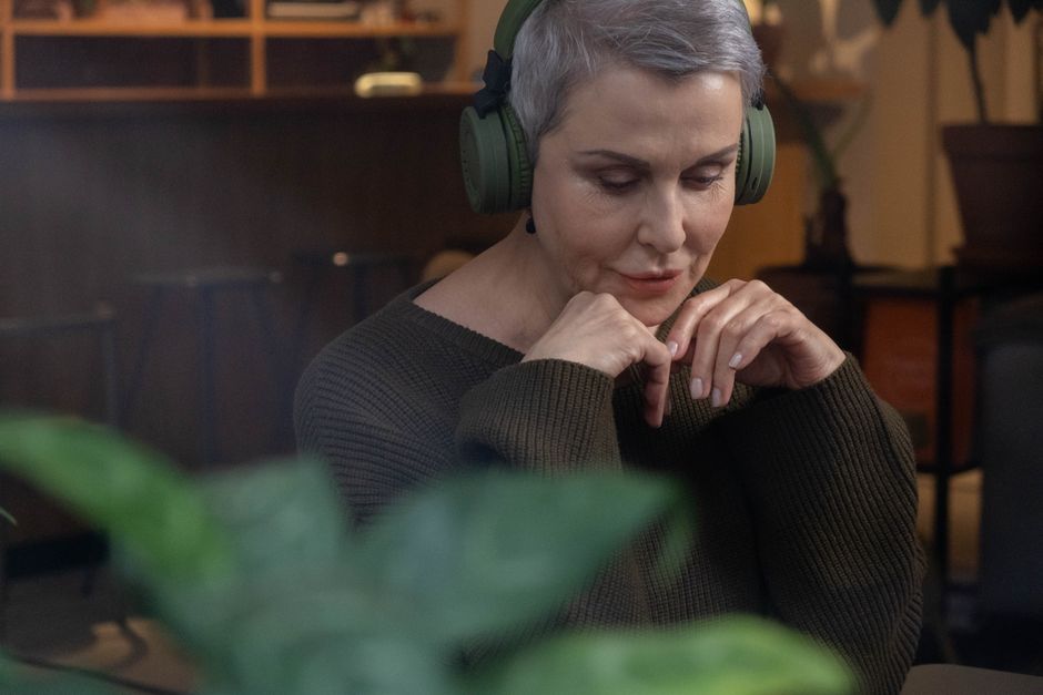 person listening to music on headphones in a cozy cafe third place lifestyle