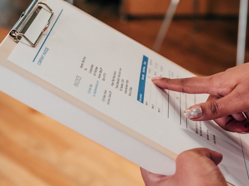 business owner reviewing invoices cash flow financing options at desk
