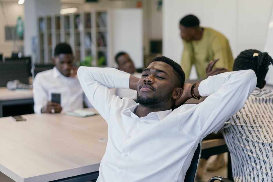 professional office worker taking a short break stretching at desk calm modern workspace